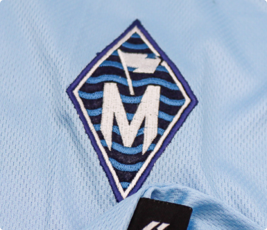 Embroidered badge stitched onto sportswear fabric